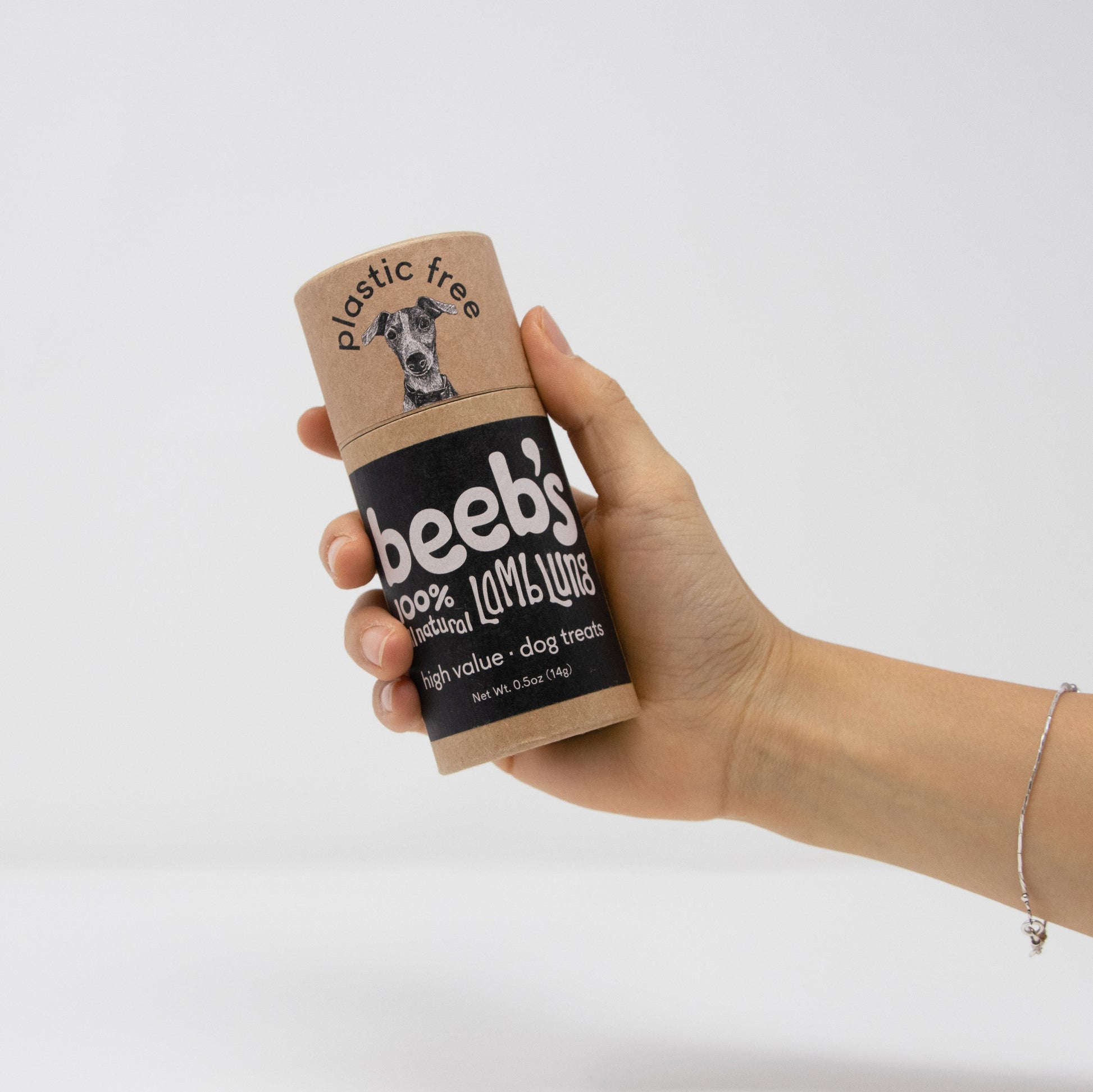 Hand holding a cardboard container labeled 'beebs' against a white background