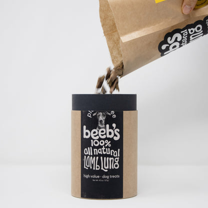 Beeb's all natural dog treats packaging being filled from a brown paper bag on a white background